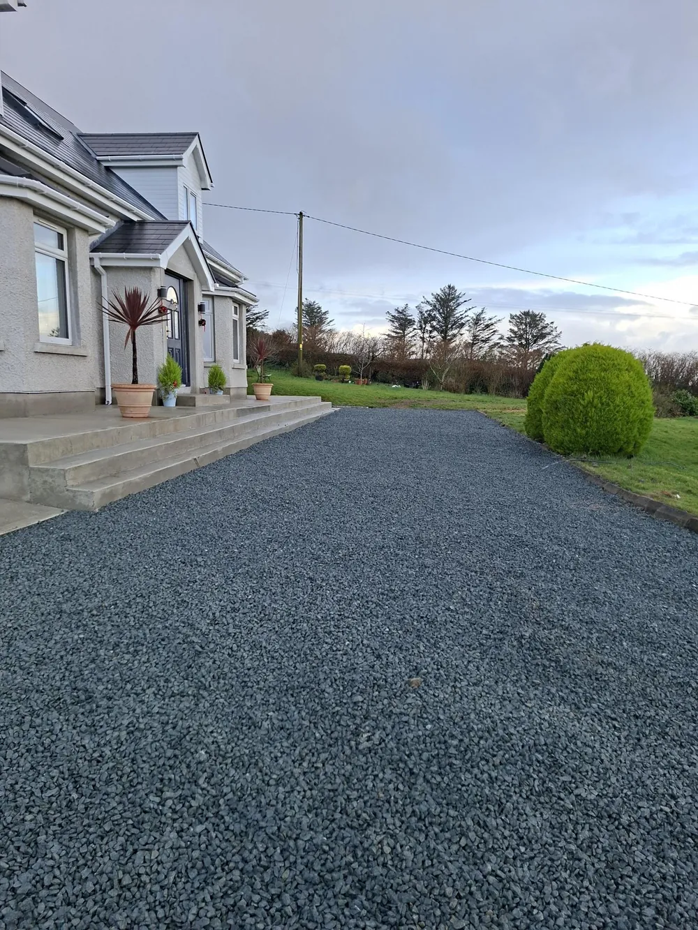 Front steps and stone driveway of a detached dormer home