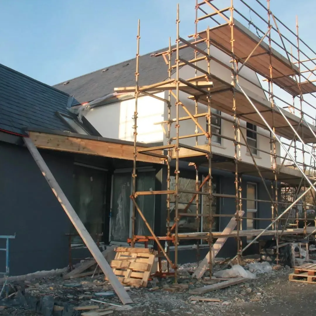 ICF house in Letterkenny with dark render on the ground floor and white above, scaffold still up
