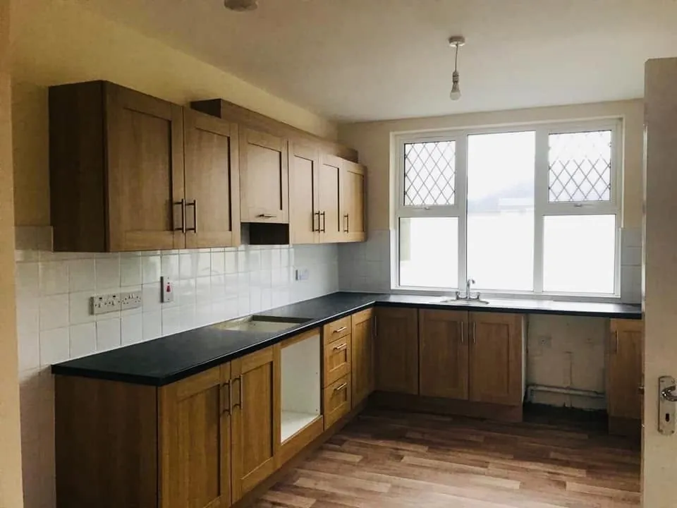 Kitchen with timber units and a dark worktop