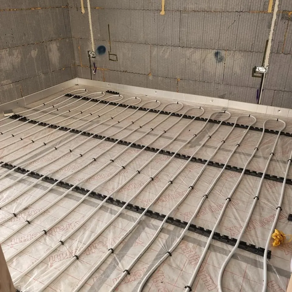 Underfloor heating pipes laid across a room