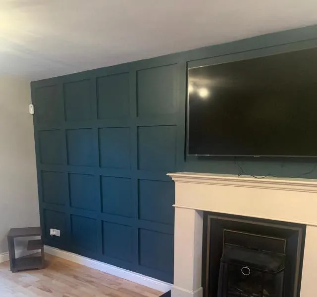 Living room after renovation with a dark panelled feature wall and fireplace