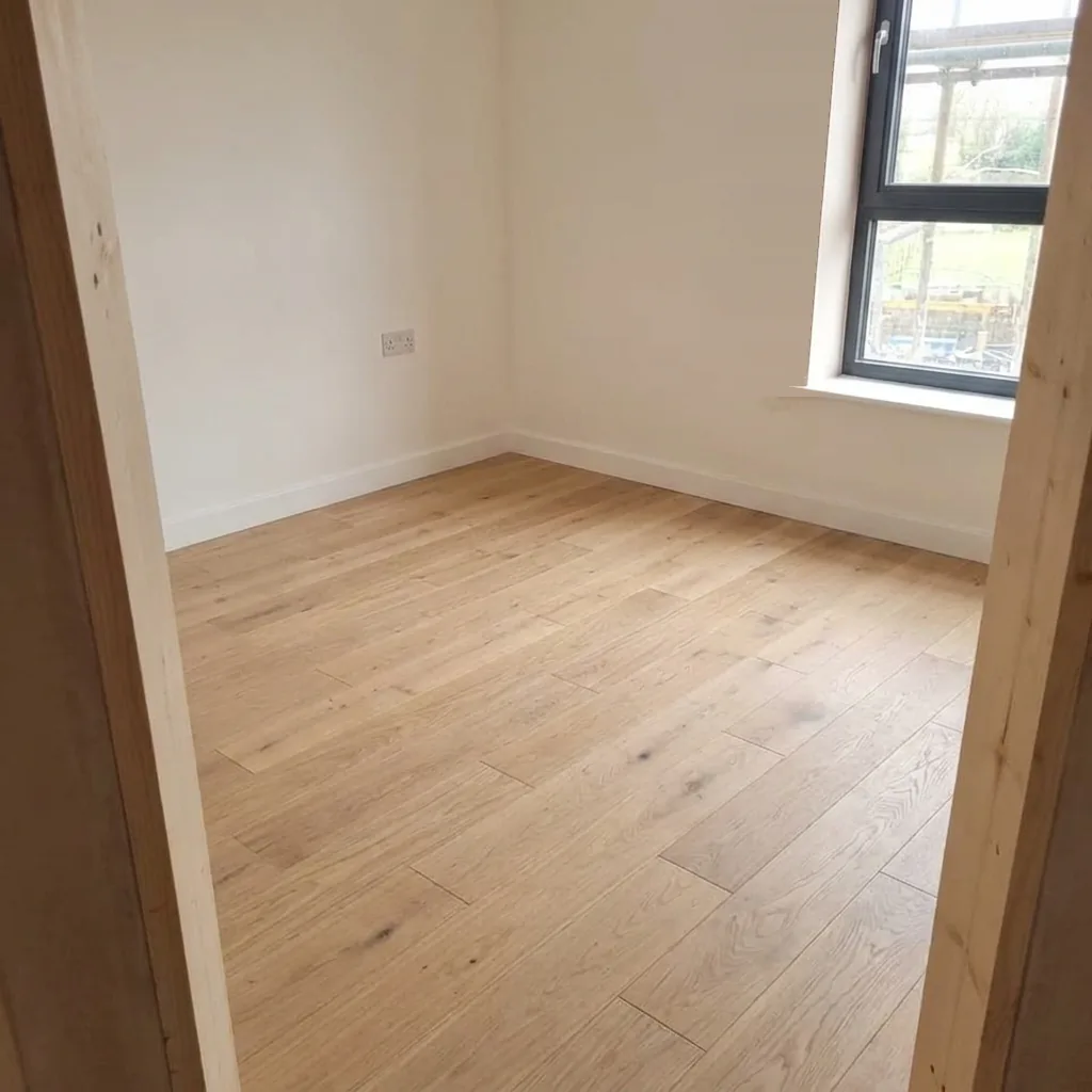 The same room finished, with plastered walls and an oak floor